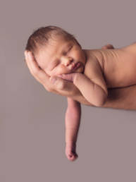 newborn baby asleep on dad's outstretched arm