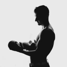 silhouette of father holding newborn baby